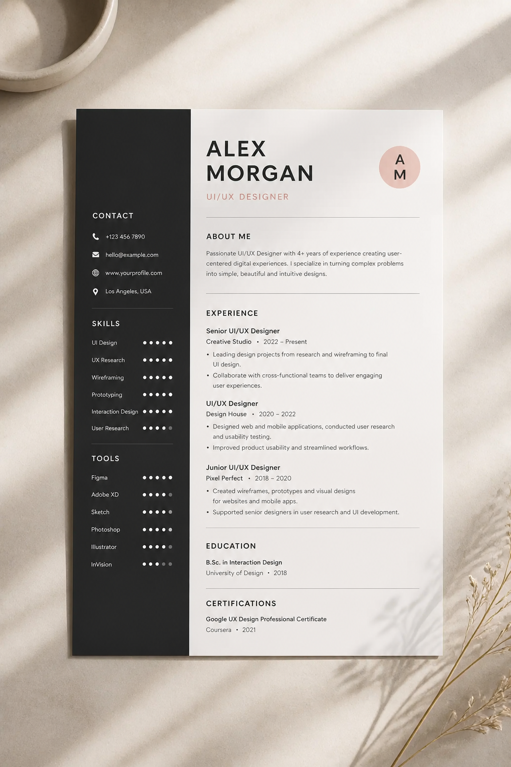 Flat lay of polished modern resume template next to a laptop and coffee cup on a wooden desk with warm morning light