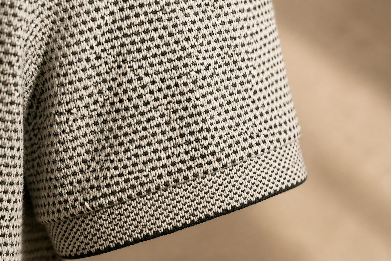 Close-up detail of the geometric pattern weave on the cotton polo sleeve in warm light