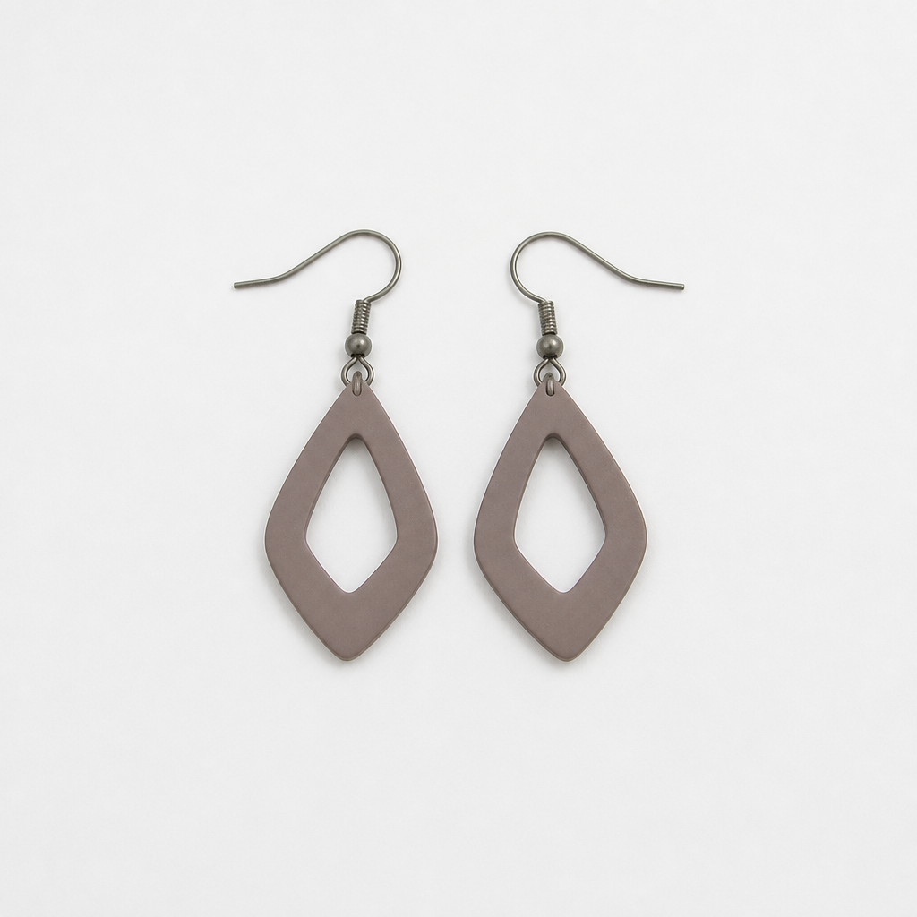 Generic dull costume earrings laid out on a plain white surface with flat lighting, no sparkle, looking tired and lifeless