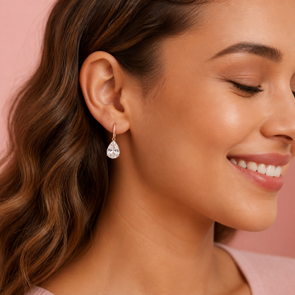Elegant teardrop silhouette of the Lunar drop earrings shown in profile against a soft pink backdrop