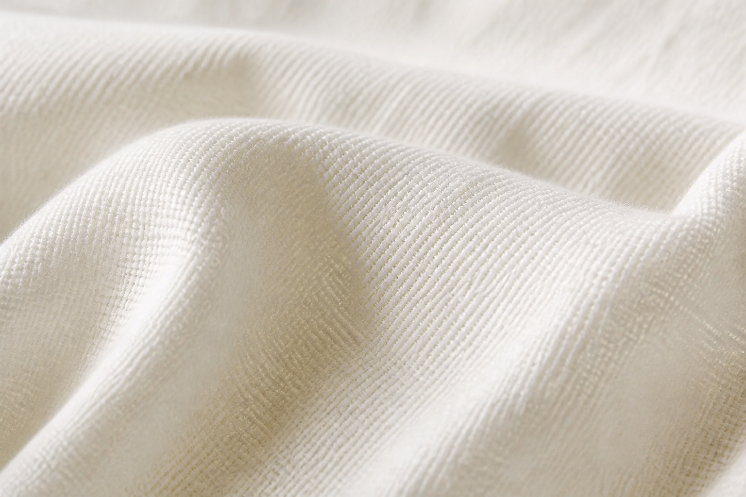 Extreme macro close-up of pure cotton fabric threads with soft warm light highlighting the natural weave texture and breathable quality of the Ladies T-Shirt material