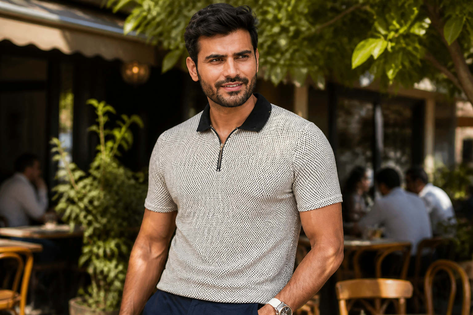 Indian man relaxing at a sunny outdoor cafe wearing the soft cotton polo, looking cool and fresh with a relaxed smile