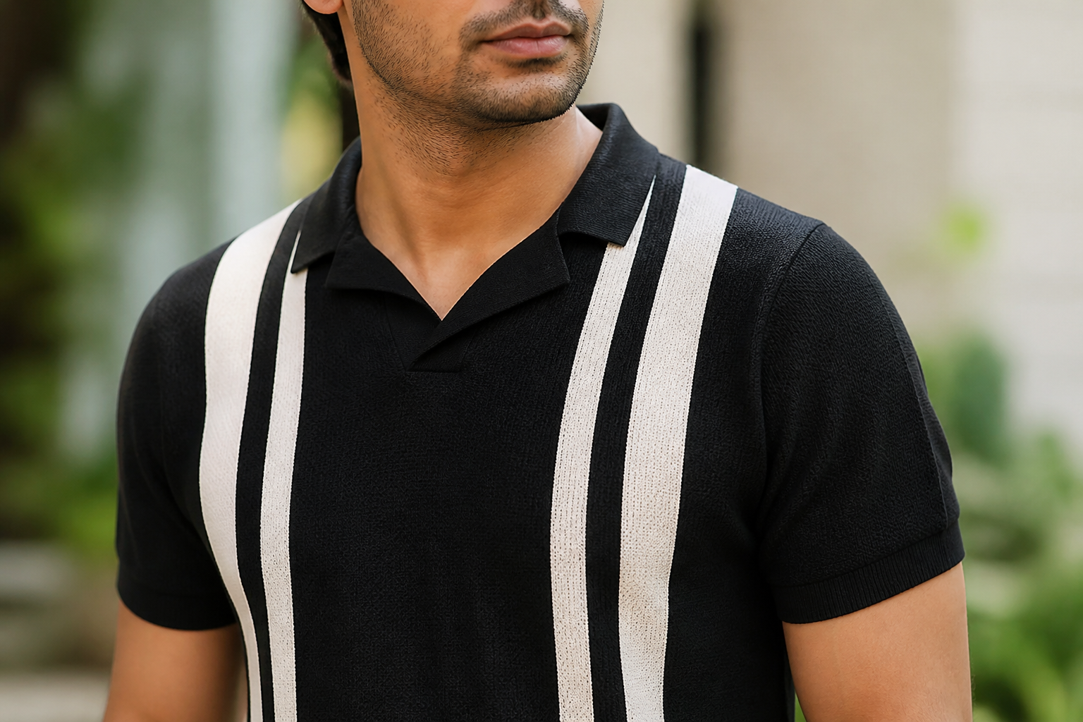 Close-up detail photograph of the retro contrast stripe running across the chest of the polo, showing off-white knit against a deep base tone