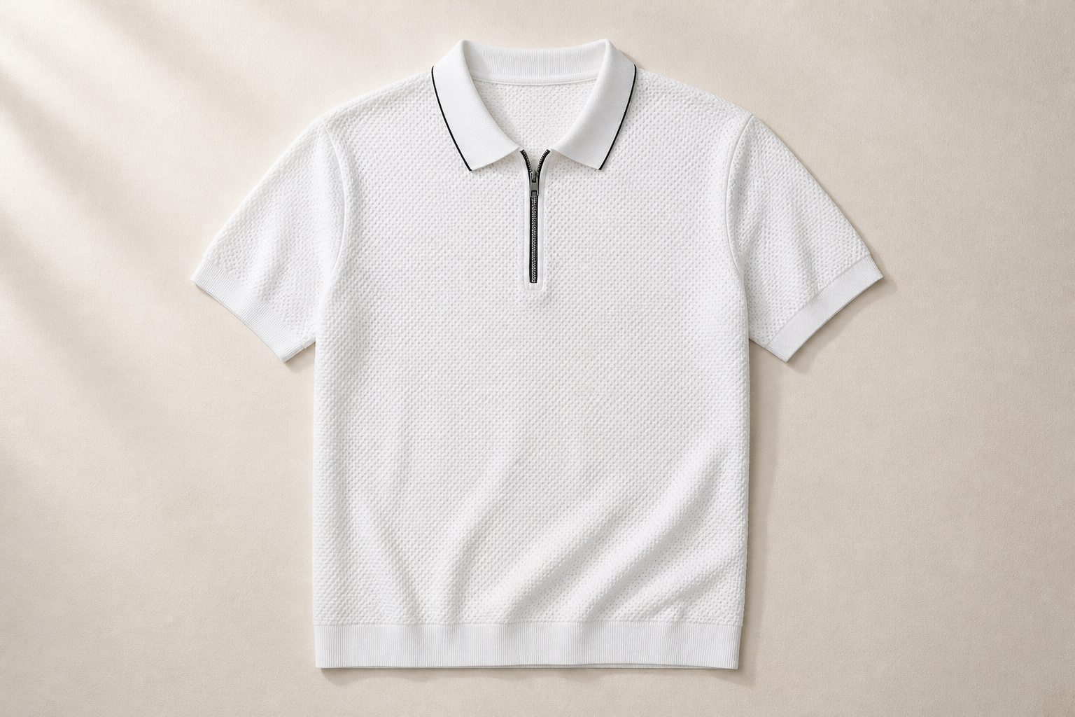 Editorial flat-lay of the Posh Monk flat-knit polo on a clean warm cream surface showing the textured knit pattern and structured collar detail