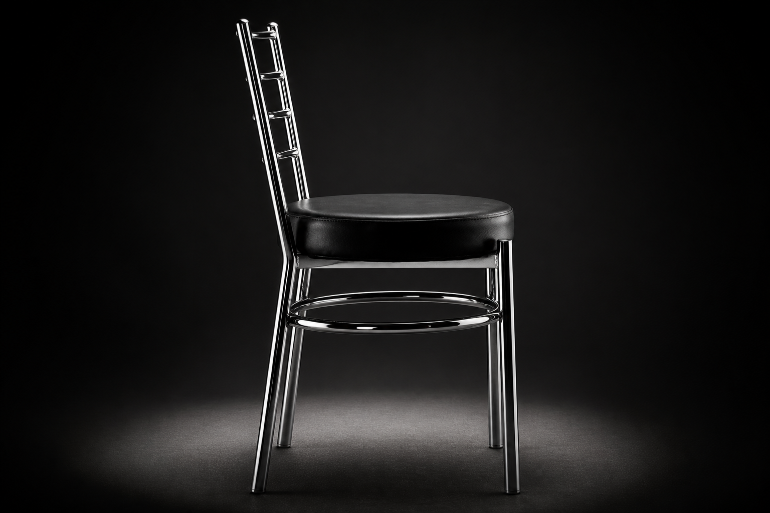 Final hero shot of the sleek black Goyal steel dining chair with cushion standing in soft spotlight on a dark studio background ready for delivery.