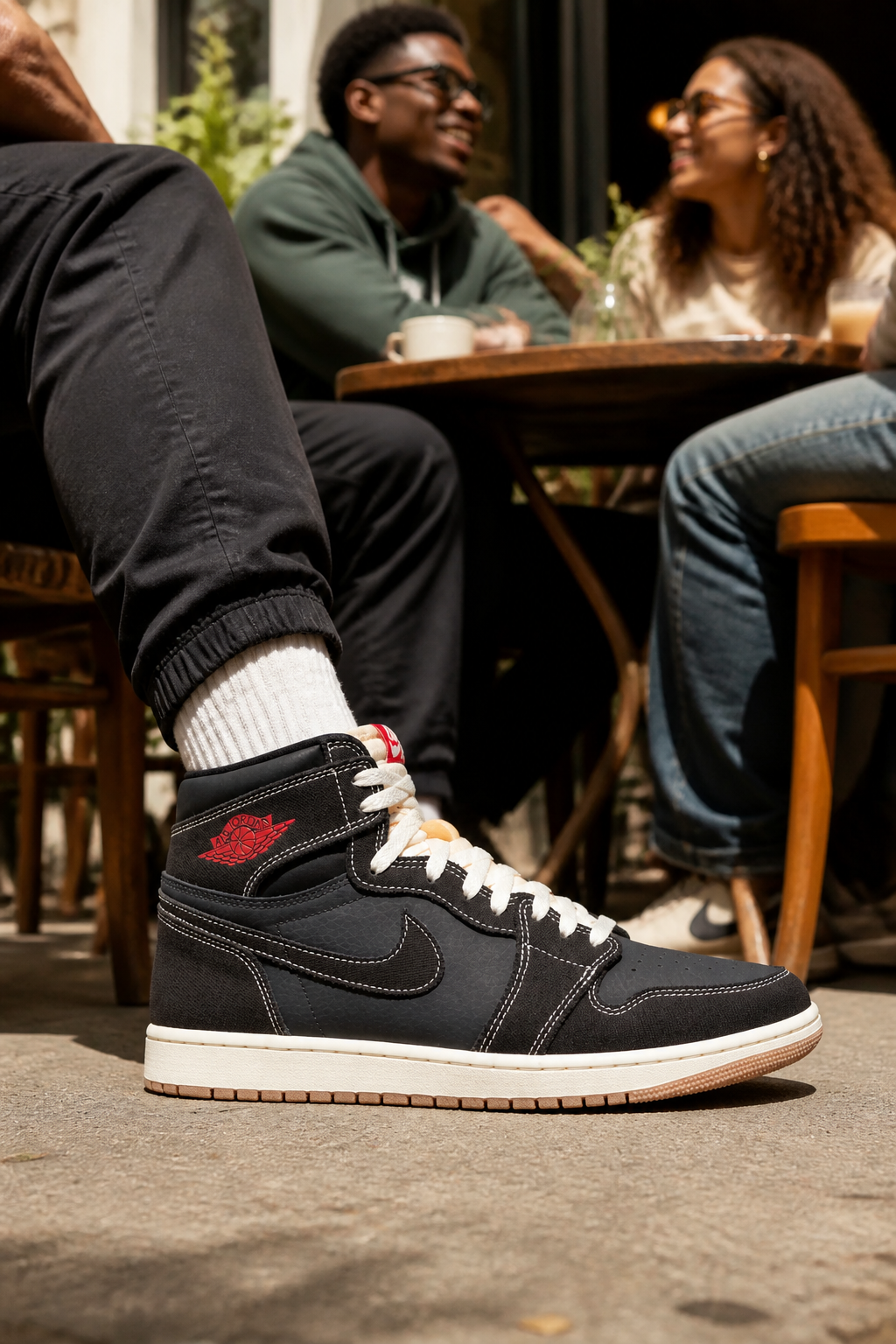 Group of friends wearing Nike Total 90 Premium sneakers hanging out at a trendy cafe outdoor patio on a sunny afternoon