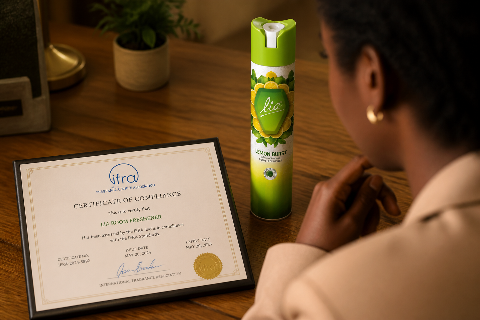 Close-up photograph of an official IFRA certificate document lying on a polished wooden table with warm indoor lighting, showing signature stamps and certification seal