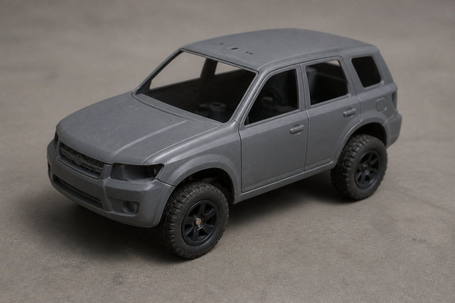 Boring plain unbranded grey plastic RC car with cheap wheels and basic controller sitting on a dull plain surface, no lights no action
