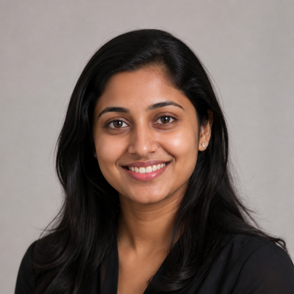 Portrait of a young Indian woman with a bright expressive smile, even studio lighting, soft beige backdrop, relaxed posture and friendly demeanor