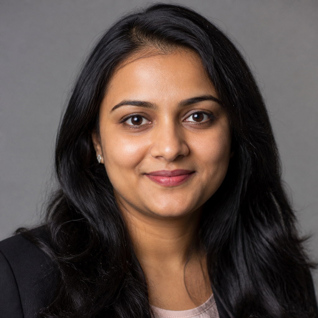 Warm close-up portrait of an Indian woman in her mid-thirties with shoulder-length dark hair, soft natural smile, wearing a casual cotton kurti, sitting on a couch in a sunlit Indian home