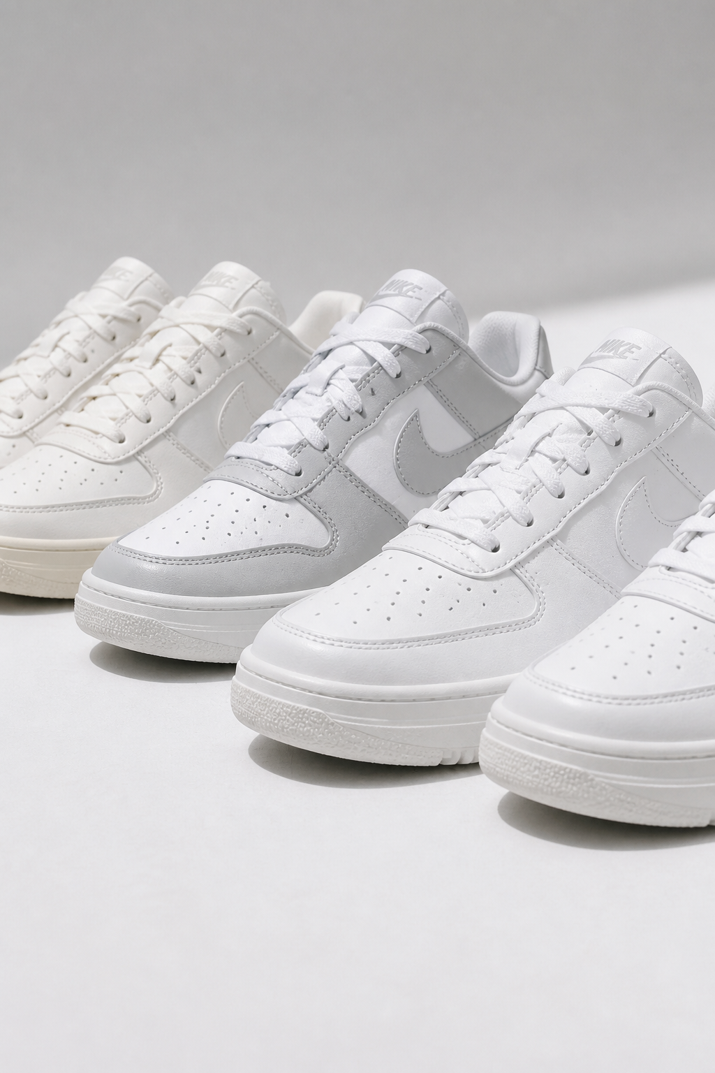 Brand new crisp Nike Sneakers 3 pair sitting on a clean white studio surface with bright natural daylight highlighting the iconic swoosh and sleek profile