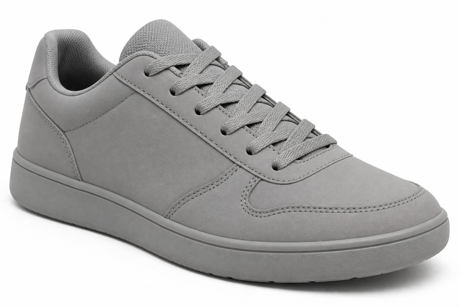 Drab unbranded plain grey sneaker photographed on a sterile white background looking dull uncomfortable and forgettable