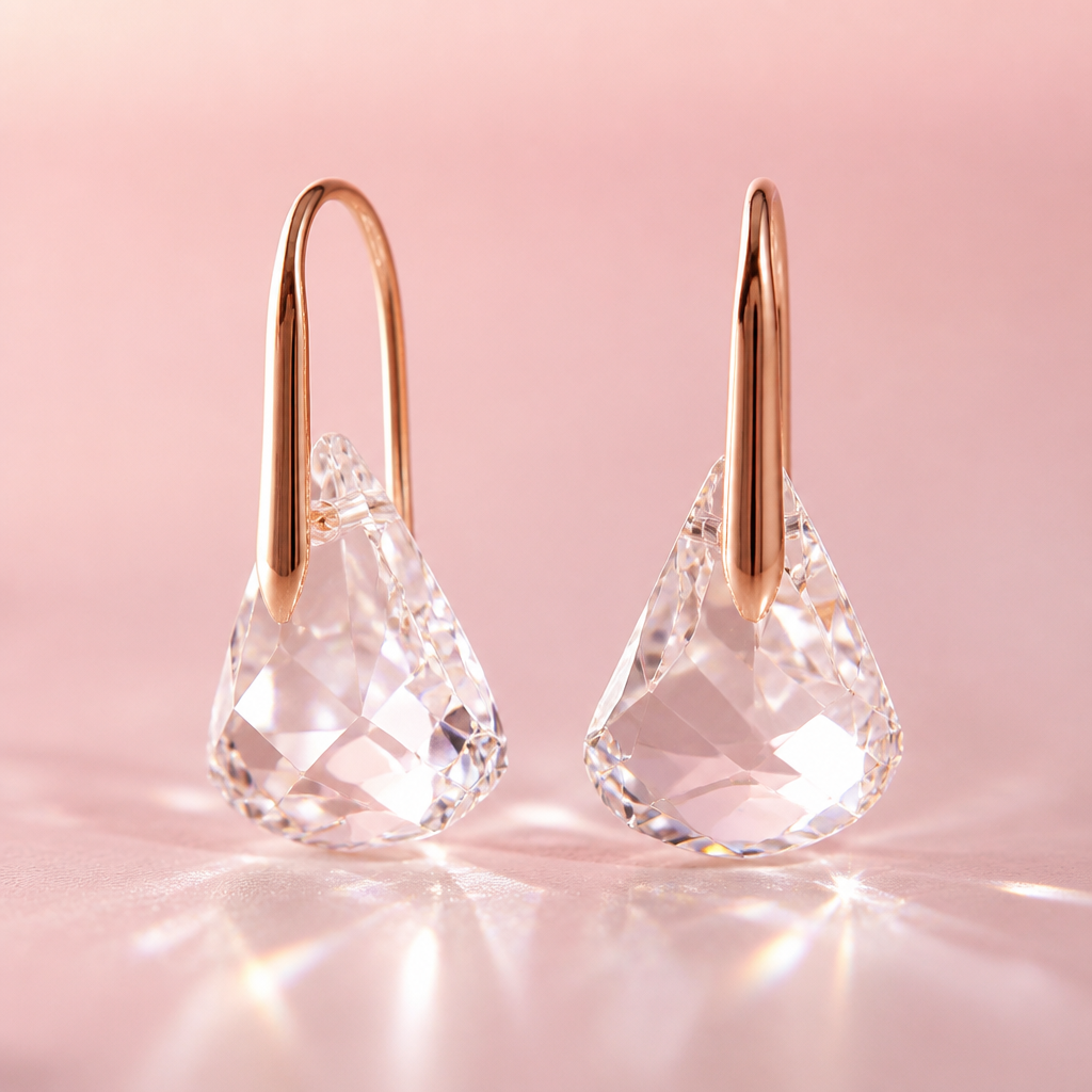 Close-up artistic shot showing the elegant water-droplet silhouette curve of the Lunar Drop earring against a soft pink gradient background with crystal light reflections