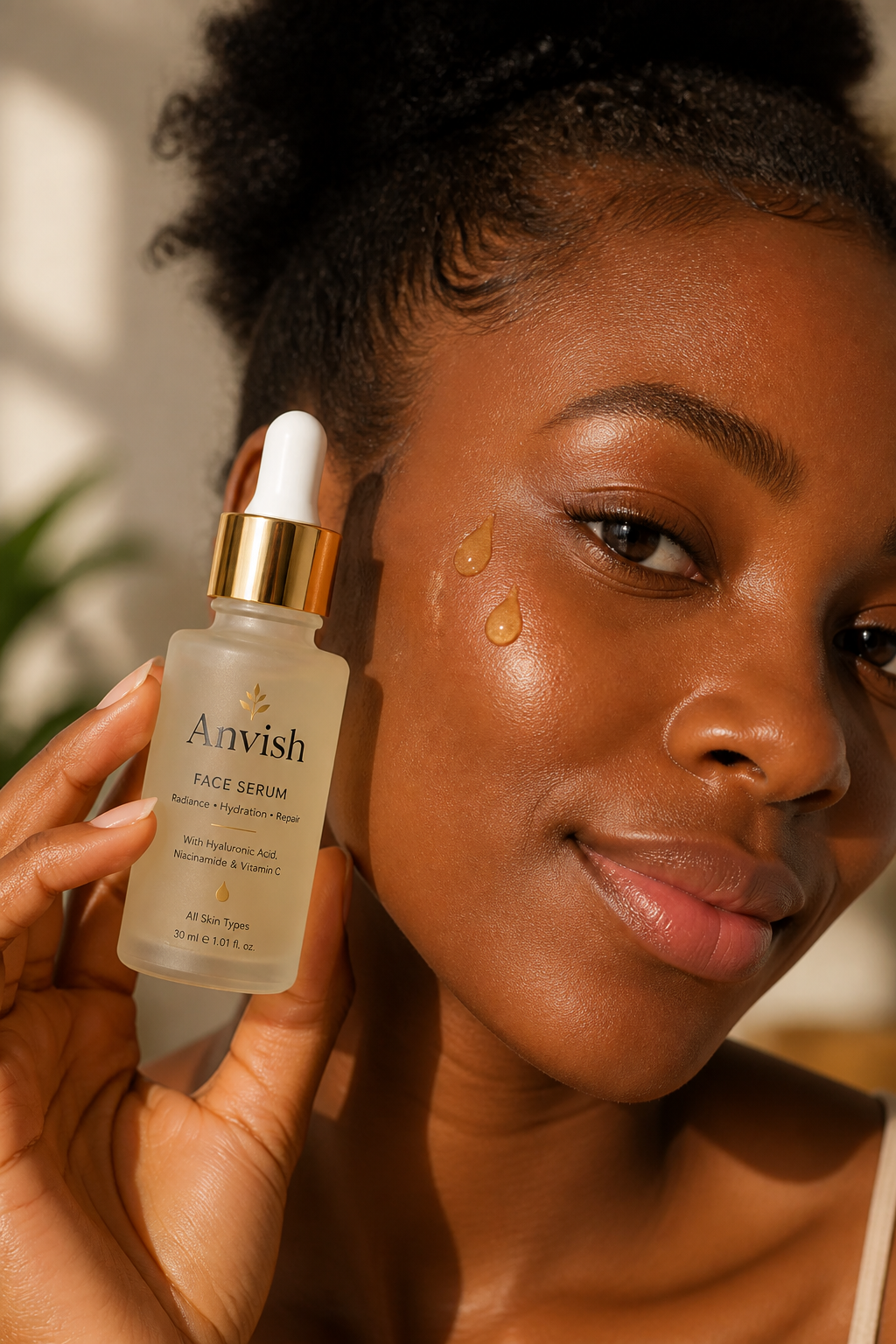 A woman with relaxed, happy smile gently pressing golden face serum drops onto her cheek in soft morning window light