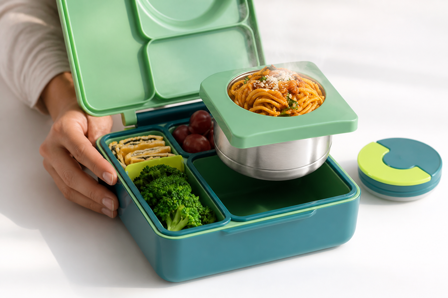 A neat fresh colorful Bento Box meal with visible steam rising from warm food inside a vibrant green container