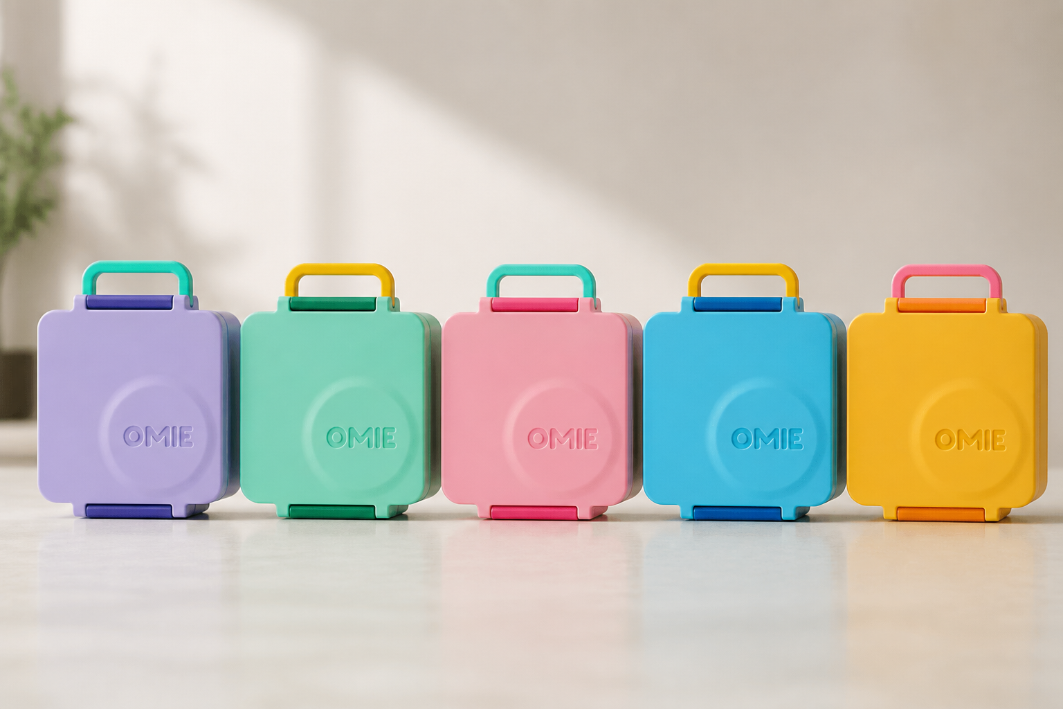 Colorful lineup of all 5 Bento Box color variants (purple, green, pink, blue, yellow) lined up together showing the vibrant matte finish and sleek rounded design
