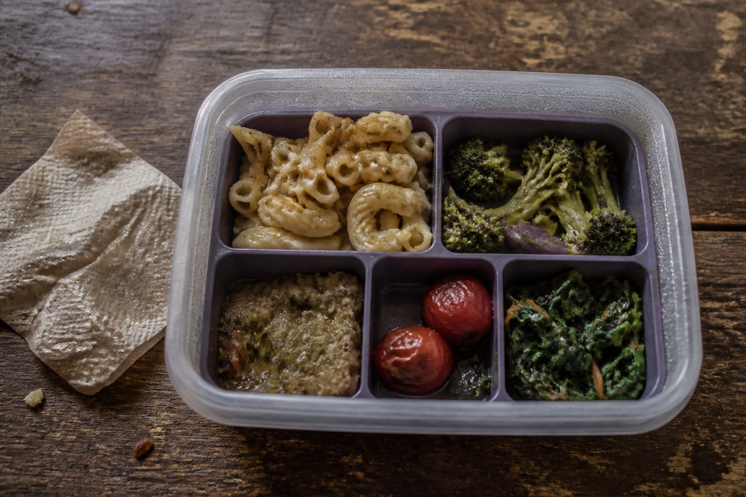 Unappetizing cold lunch in a generic container showing soggy pasta and wilted vegetables with condensation droplets